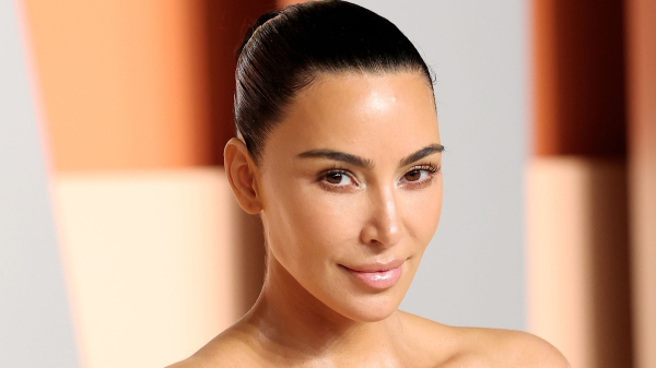 Kim Kardashian appears on the red carpet at the Oscars afterparty in a white strapless gown and minimal makeup. She...